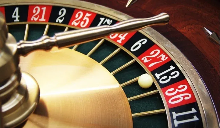 Primer plano de un cilindro de ruleta americana con las casillas numeradas y el brazo cruzado del rotor.